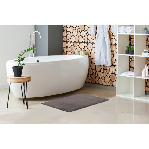 Grauer Badezimmerteppich vor freistehender weisser Badewanne in modernem Spa-Badezimmer mit Holzwand