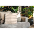 Lalee Plush Kissen in Creme mit Rillenstruktur auf grauem Sofa vor grünen Zimmerpflanzen