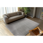 Grauer Lalee Comfort Teppich mit geschwungenen Linien im modernen Wohnzimmer mit Ledersessel und Beige-Sofa