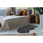 Lalee Cosy Kunstfellteppich Graphit 60x90cm im modernen Schlafzimmer mit Holzelementen und Naturpflanzen