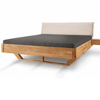Balkenbett aus Holz mit beigem Cordkopfteil und grauer Matratze, modernes Designermöbel.