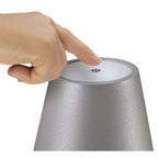 Finger drückt Power-Button auf silberner LED-Flaschenlampe Luce von Cilio Küchenprofi