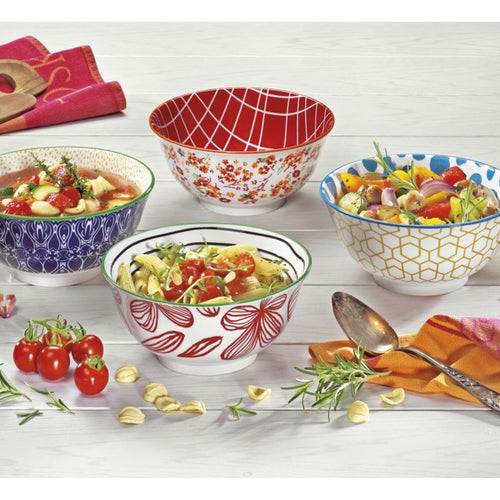 Bunte Müslischalen mit floralen Mustern gefüllt mit Pasta und Gemüse auf weißem Holztisch