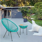 Türkis-grüner Gartensessel Spaghetti Parker mit Beistelltisch auf moderner Terrasse vor Designhaus