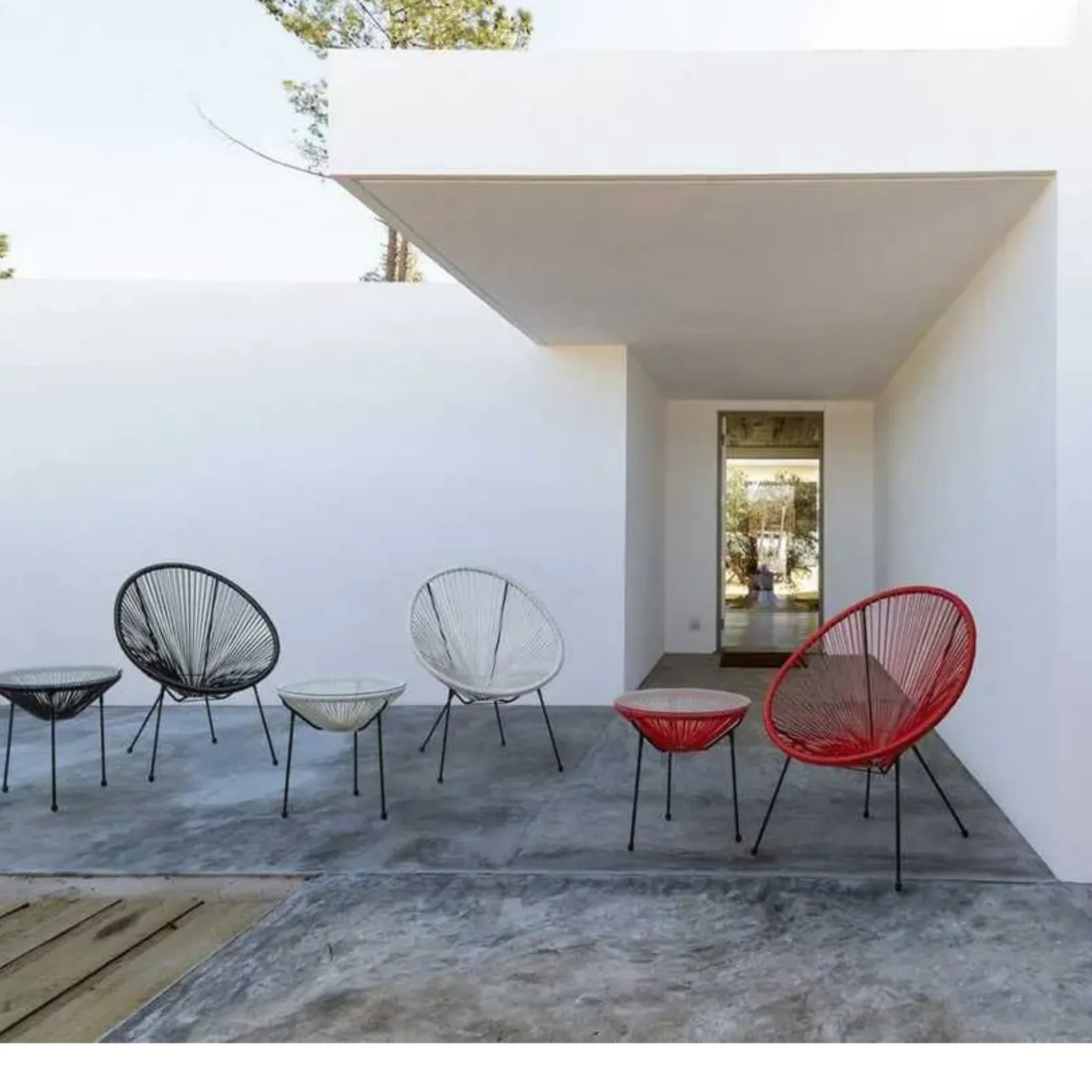 Moderne Gartensessel Spaghetti Parker in Schwarz, Weiß und Rot auf Terrasse unter Überdachung.