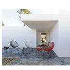 # Alt-Text:

Moderne Gartenmöbel: Bunte Lounge-Stühle und Beistelltische auf Terrasse mit weißer Architektur