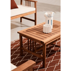Bizzotto Gartenlounge Set Noemi Akazie – Holztisch mit weißem Accessoires auf braunem Teppich