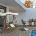 Holz-Hollywoodschaukel Noemi mit weißem Dach und Kissen auf Terrasse mit Pool und Gartenmöbel-Set