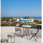 Bizzotto Gartentisch Paloma rund 60cm auf sonniger Terrasse mit Meerblick und Blumen