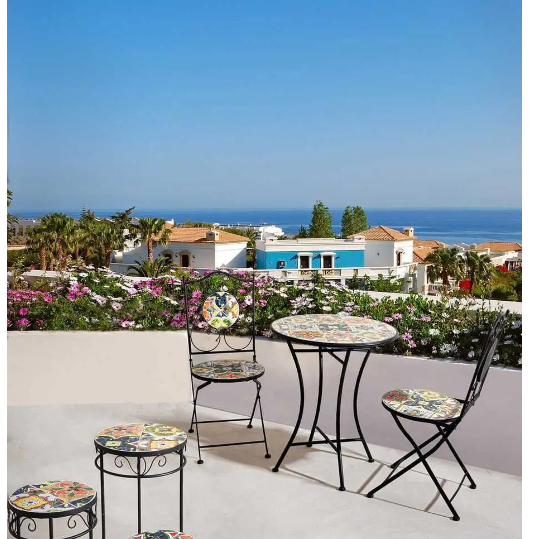 Bizzotto Gartentisch Paloma rund 60cm auf sonniger Terrasse mit Meerblick und Blumen