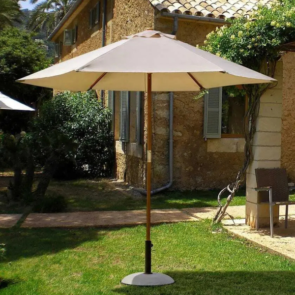 Sonnenschirm Syros rund 250 cm beige im Garten vor mediterranem Steinhaus mit Ständer