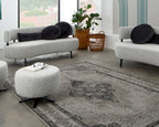 Grauer Drehhocker Ponsel im modernen Wohnzimmer mit hellgrauem Sofa und orientalischem Teppich