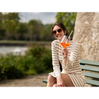 Frau genießt Aperol Spritz im Freien aus Zwiesel Kristallglas Cocktailglas auf Parkbank