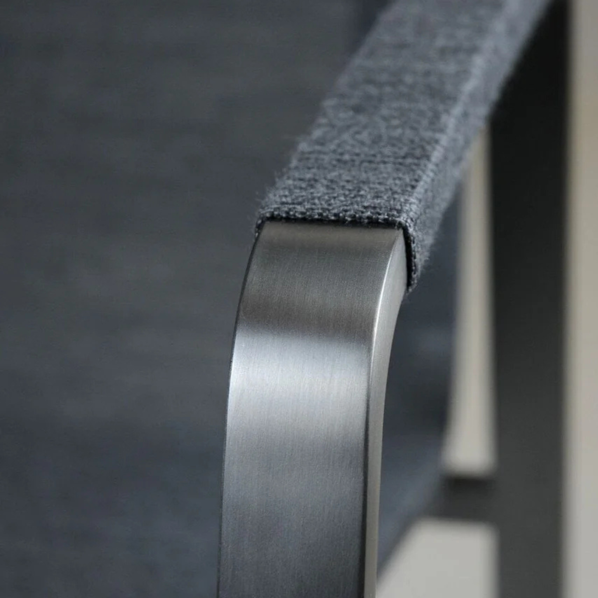 Sitmobilia Tinto Preto Möbel: Schwarze moderne Möbelkante mit gebürstetem Metalldetail und grauer Stoffoberfläche in Nahaufna