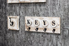 HAKU Möbel Schlüsselboard aus Massivholz Motiv Baumscheibe und Schriftzug in Grau