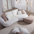 Megasofa New Spirit in Weiss mit Bouclé-Stoff, organischer Form und Taupe-Hocker im modernen Wohnzimmer