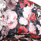Gutmann Sessel Tiptoe Detailaufnahme mit floralem Blumenmuster in Rot, Rosa und Grau auf dunkelblauem Stoff