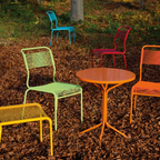 Bunte Gartenmöbel Set mit Tisch und Stühlen von Schaffner in Türkis, Gelb und Orange auf Herbstlaub.