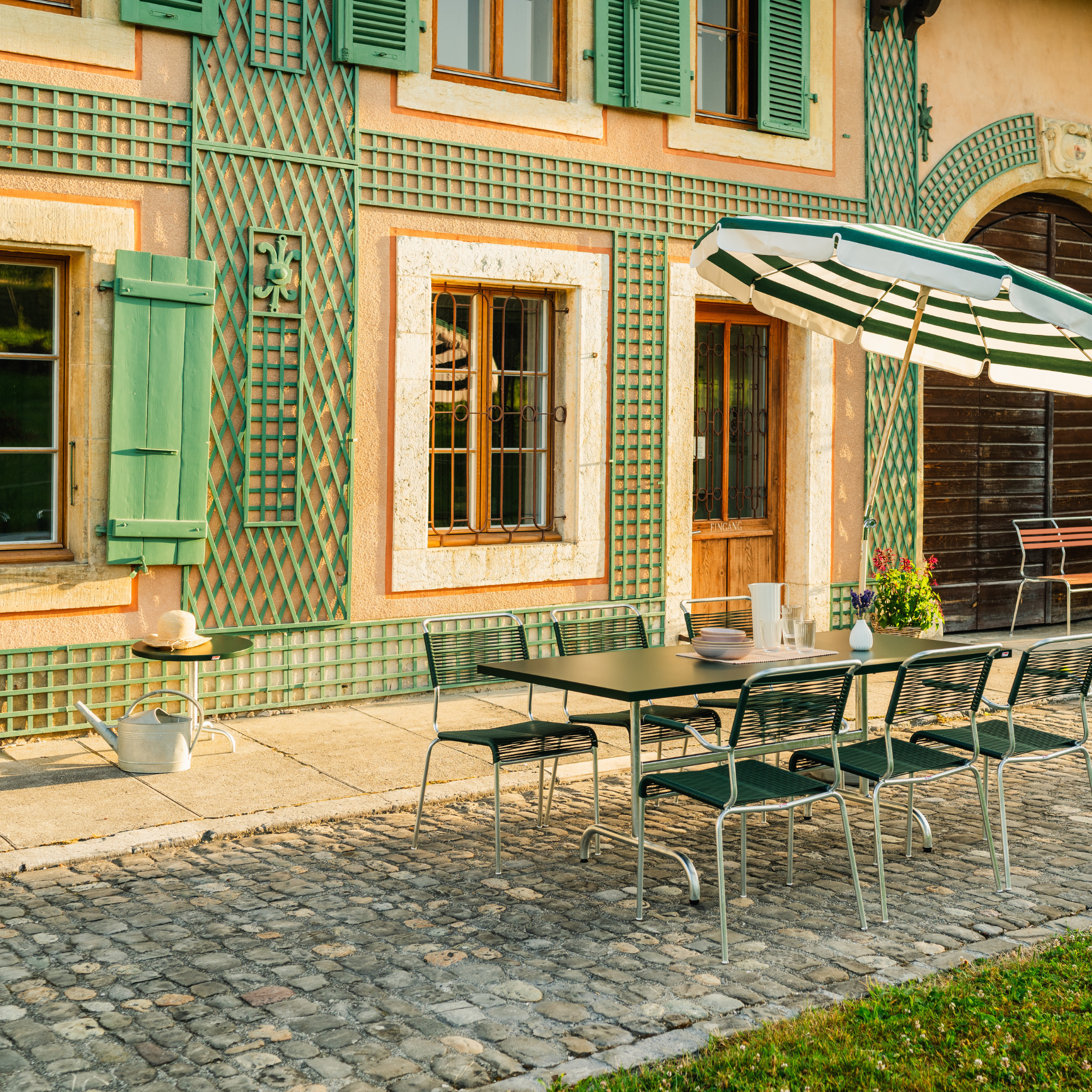 Schaffner Spagettistuhl Olive-Kaliblau auf sonniger Terrasse eines modernen Schweizer Möbelhauses