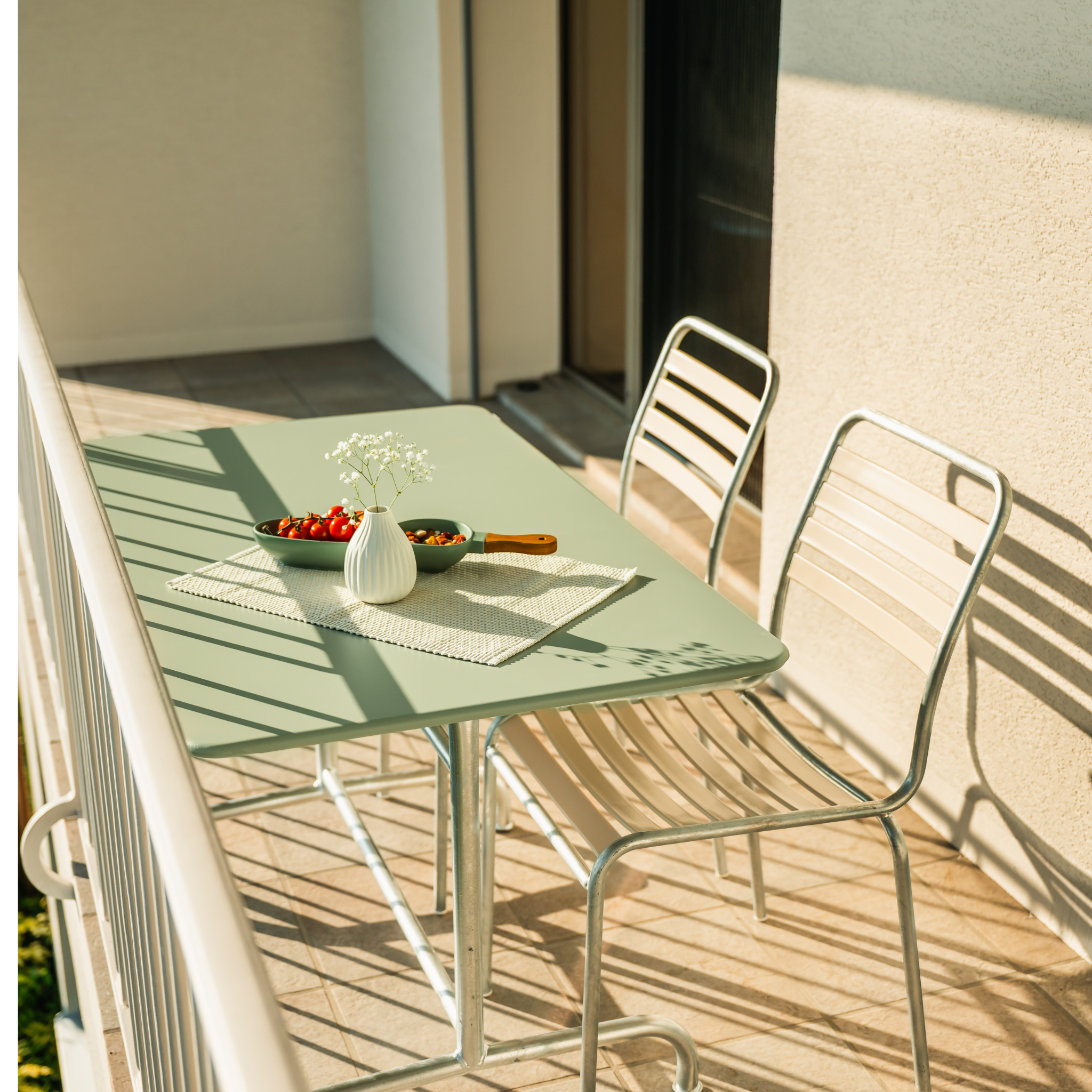 Schaffner Metalltisch Rigi 140x80cm Pastellgrün mit Stühlen auf sonniger Terrasse