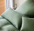 Grüne Jersey Cord Bettwäsche mit Kissenbezügen auf einem Bett im gemütlichen Schlafzimmer