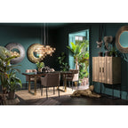 Luxuriöses Esszimmer mit KARE Möbeln, smaragdgrünen Wänden, Designerleuchte, Holzschrank und tropischen Pflanzen